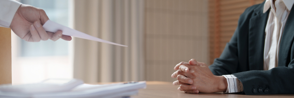 Klage eines Generalintendanten gegen eine außerordentliche Kündigung Hand reicht sitzenden Mann ein Blatt, eine Kündigung