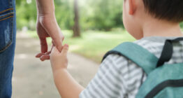 Kind und Mutter auf dem Schulweg, Nahaufnahme Hände